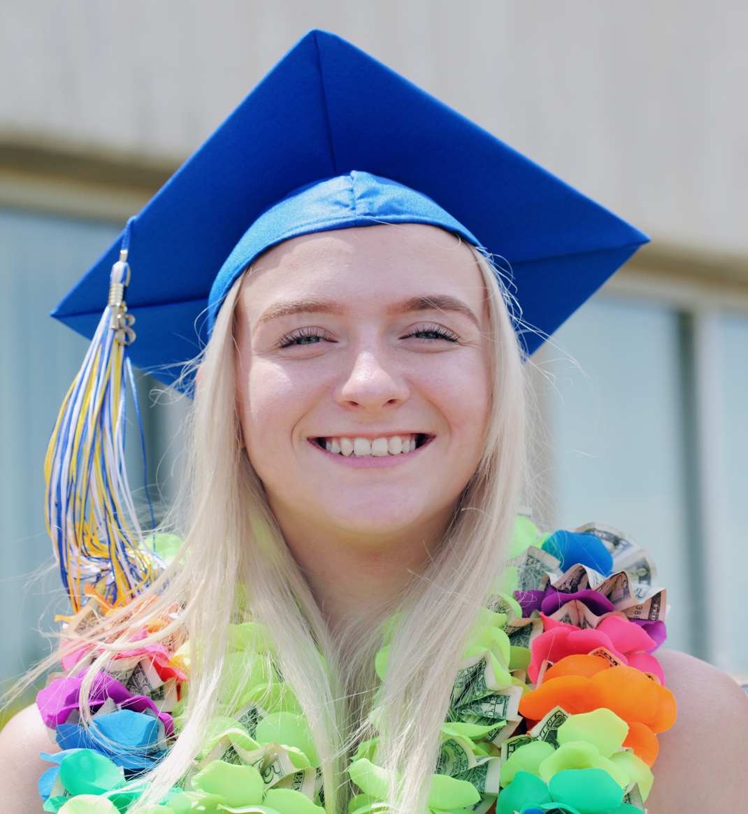 A person wearing a graduation cap and gown Description automatically generated